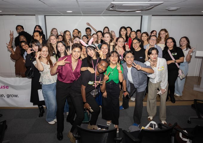 A large, diverse group of Soo House members posing together at a community celebration, with the Soo House brand banner visible behind them